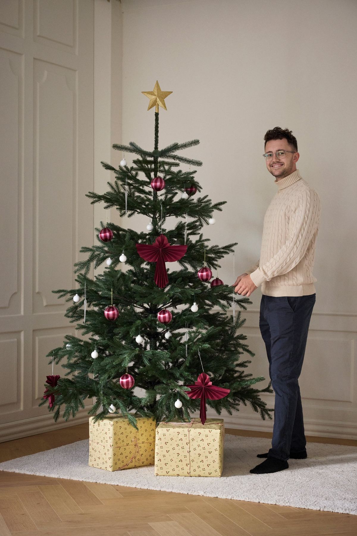 Magnus fra TreeTime ved et pyntet juletræ i stuen